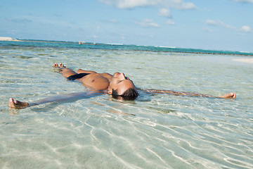 Image showing Man floating in water on the beach