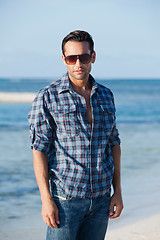 Image showing Man wearing sunglasses and standing on the beach