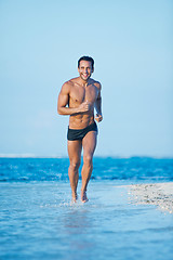 Image showing Man running in water on the beach