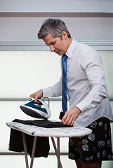 Image showing Businessman ironing pants