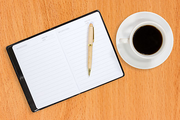 Image showing Notebook and coffee cup on the table