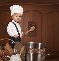 Image showing boy in a cook cap among pans and vegetables