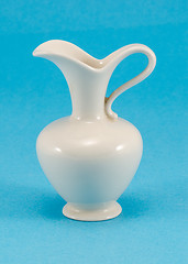 Image showing cute shape white ceramic pitcher jug jar on blue 