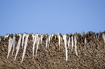 Image showing icicles retro straw roof background blue sky 