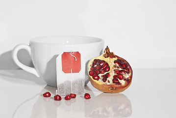Image showing Juicy pomegranate and tea bag