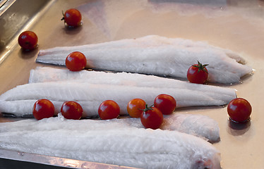 Image showing some pieces of raw cod and tomatoes