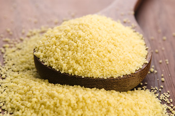 Image showing couscous in wooden spoon on kitchen table