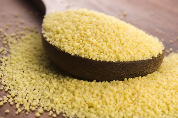 Image showing couscous in wooden spoon on kitchen table