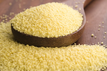 Image showing couscous in wooden spoon on kitchen table