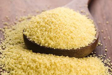 Image showing couscous in wooden spoon on kitchen table