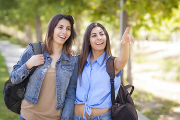 Image showing Mixed Race Twin Sisters Wearing Backpacks and Pointing Outside