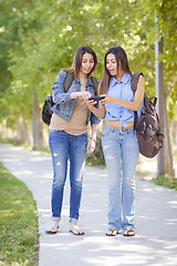 Image showing Young Adult Mixed Race Twin Sisters Sharing Cell Phone Experienc