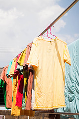 Image showing Colorful clothing drying on clothesline under sunlight 