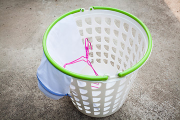 Image showing Empty white plastic laundry basket on the floor