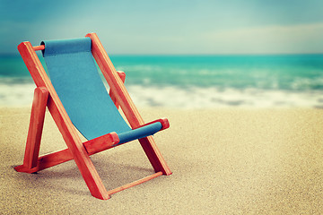 Image showing Sun lounger in sandy beach vintage toned