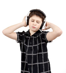 Image showing Portrait of a happy young boy listening to music on headphones