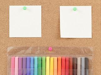 Image showing color markers with notes on cork board 