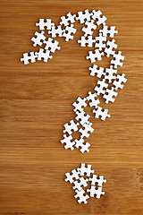 Image showing Question mark made by puzzle on wood background 