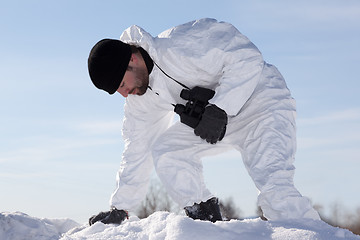 Image showing Wounded soldier in white camouflage sneaking through the mountai