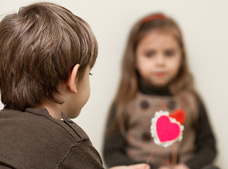 Image showing Boy gives heart to little girl