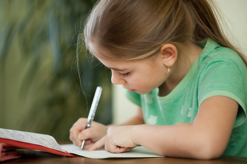 Image showing Pre-adolescent girl concentrates on her studies