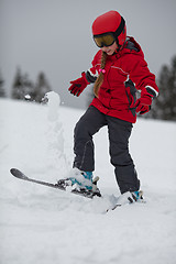 Image showing Young girl skier tosses up  snow