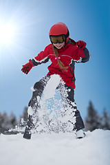 Image showing Young girl skier plays with snow