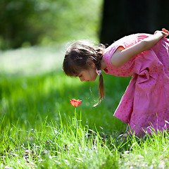 Image showing Little girl sniffing flower