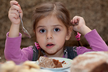 Image showing Look of little girl eating cake