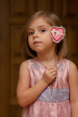 Image showing Cute little girl holding up a heart shape