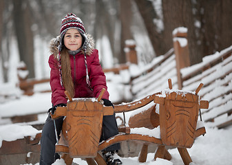Image showing Smiling girl on woody cow