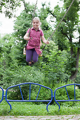 Image showing Girl swinging with a big smile