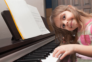 Image showing Little girl playing piano