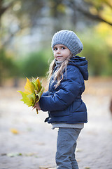 Image showing Little girl holding the bouquet from leaves