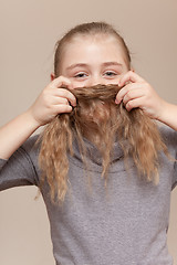 Image showing Little girl making  moustache