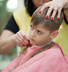 Image showing Cute young boy getting haircut