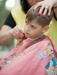 Image showing Cute young boy getting haircut