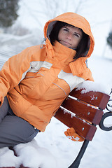 Image showing Woman on snowy bench