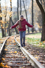 Image showing Girl walking down train tracks