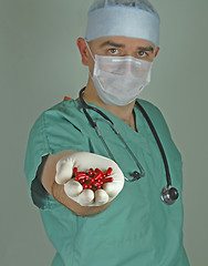 Image showing Doctor giving the red capsules