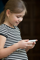 Image showing Little girl reading sms on phone