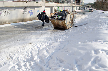 Image showing man carries four bags garbage house container 