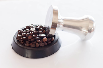 Image showing Coffee tamper and roasted coffee in rubber saucer