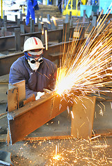 Image showing worker using torch cutter to cut through metal