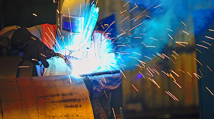 Image showing worker with protective mask welding metal 