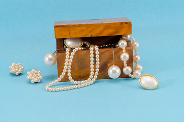 Image showing pearl jewelry retro wooden box on blue background 