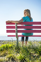 Image showing Pretty woman on pink bench