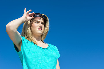 Image showing Woman raising sunglasses