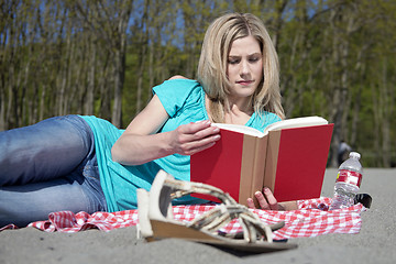 Image showing Attractive woman reading a book on a beach