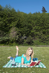 Image showing Woman reading a book in a park